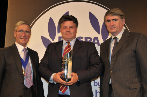 Former RoSPA President Lord Jordan of Bournville (left) and RoSPA chief executive Tom Mullarkey (right) present Anthony Withers-Green, director of global business for Tristar Chauffeur, the Fleet Safety Technology Trophy