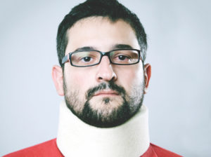 Man in red top with neck brace