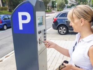 Woman paying at parking meter