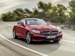 Mercedes-Benz E-Class Coupé in red driving on road